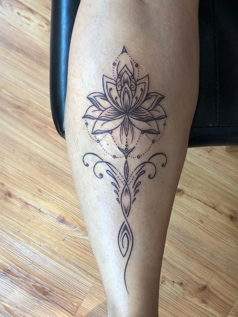 Tatuagem fineline de flor de lótus na perna