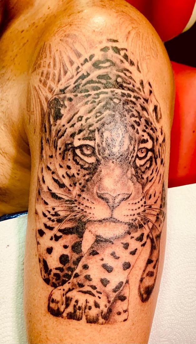 Tatuagem realista de onça no braço