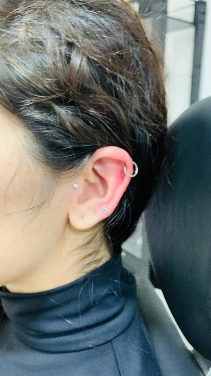 Procedimento de piercing sendo realizado no estúdio